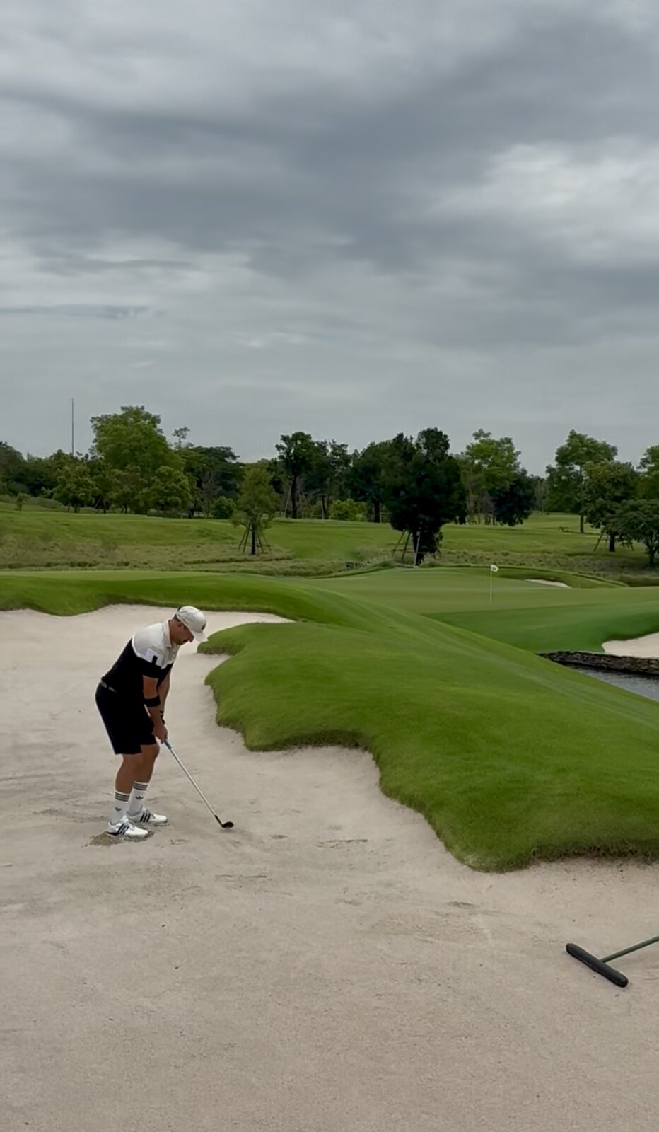 A golfer practising a bunker shot on the course
